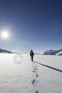 男远足者行走在雪上的足迹图片