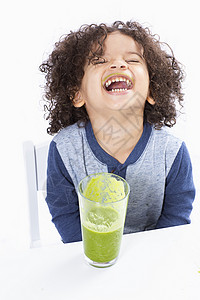 回头的男孩男孩喝绿色的果汁背景