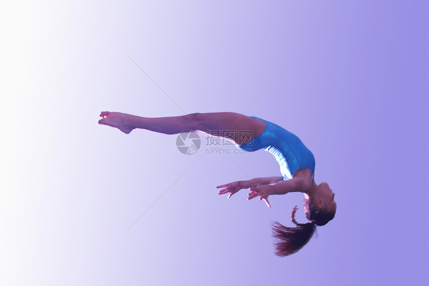 空中飞跃的年轻体操运动员图片