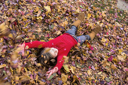 秋叶里玩耍的女孩图片