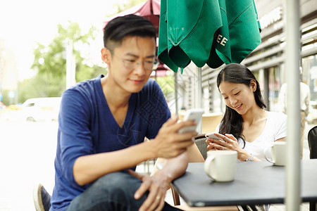 上海咖啡馆的旅游夫妇在玩手机图片