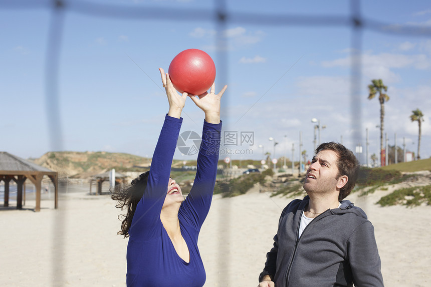 在以色列特拉维夫海滩玩球的年轻夫妇图片