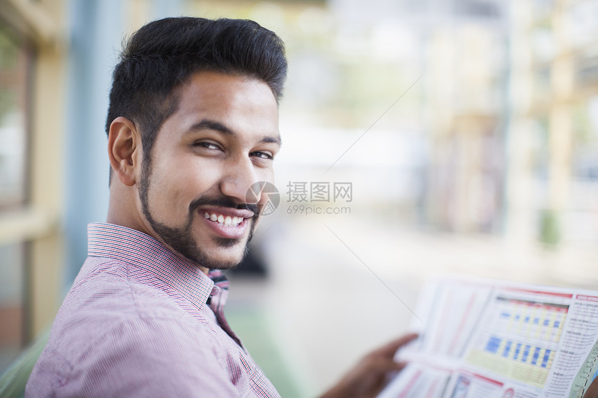 青年商人在火车站阅读报纸图片