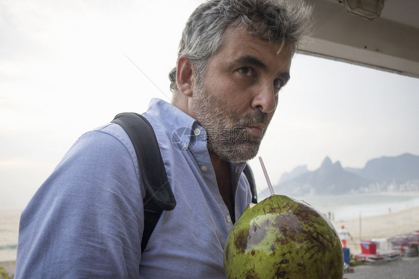 喝新鲜椰子汁的人巴西里约热内卢伊帕马海滩图片