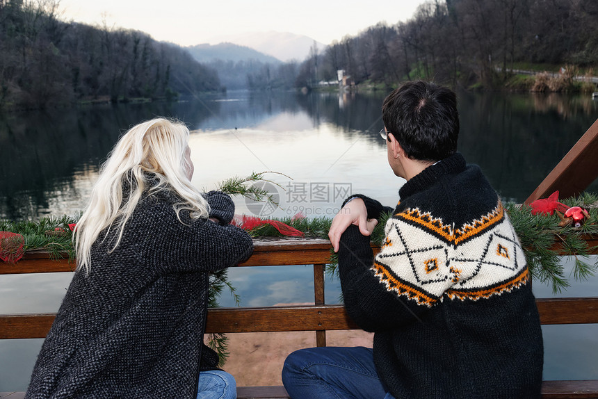 意大利伦巴第市Lombardy市湖边坐在长椅上看风景的异恋夫妇图片
