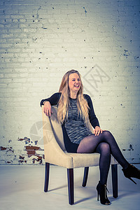 一位坐在椅子上笑的年轻女士演唱室肖像图片