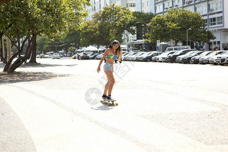 巴西里约热内卢科帕卡巴纳年轻女子在人行道上滑板图片