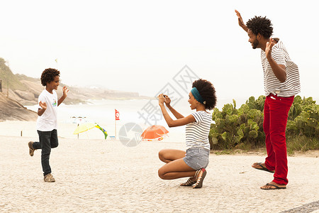 在巴西里约热内卢Ipanema海滩上拍摄家庭照片的男孩图片