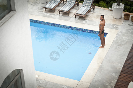 站在游泳池旁的男人图片