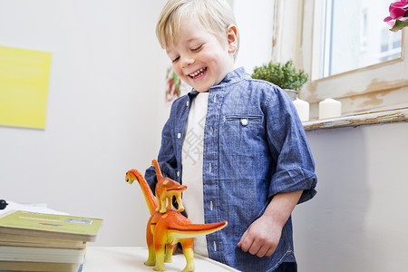 在家里玩玩具恐龙的男孩图片