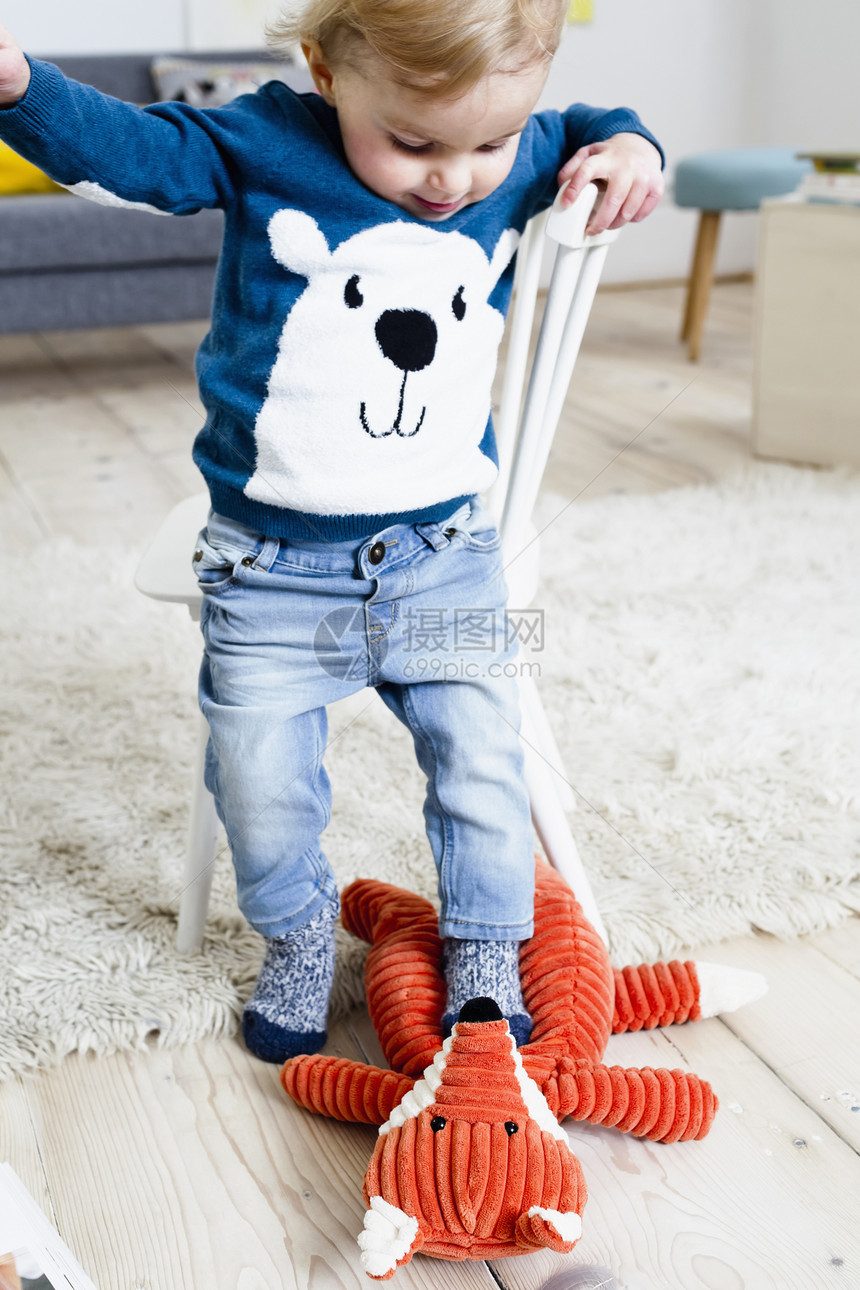 男孩踩着玩具玩图片