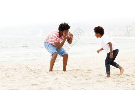 父亲和儿子在海滩上玩耍图片