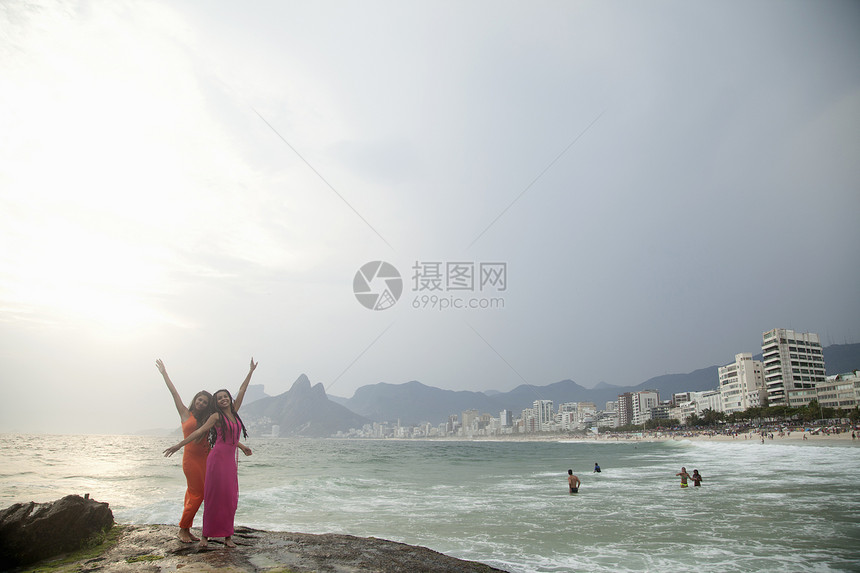 在巴西里约热内卢Ipainema海滩上举起对两名年轻妇女的肖像图片