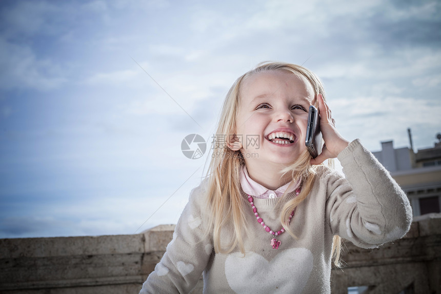 年轻女孩在使用智能手机微笑的打电话图片