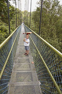 在新加坡植物园里的长桥上站着男孩图片