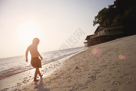 马来西亚拉瓦岛的日光海滩上漫步的男孩图片