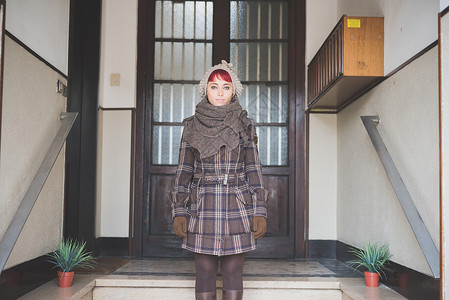 穿着冬装站在门口的年轻女子肖像图片