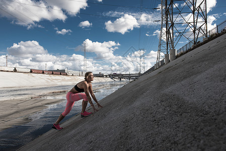 在陡峭水渠上移动女跑者图片
