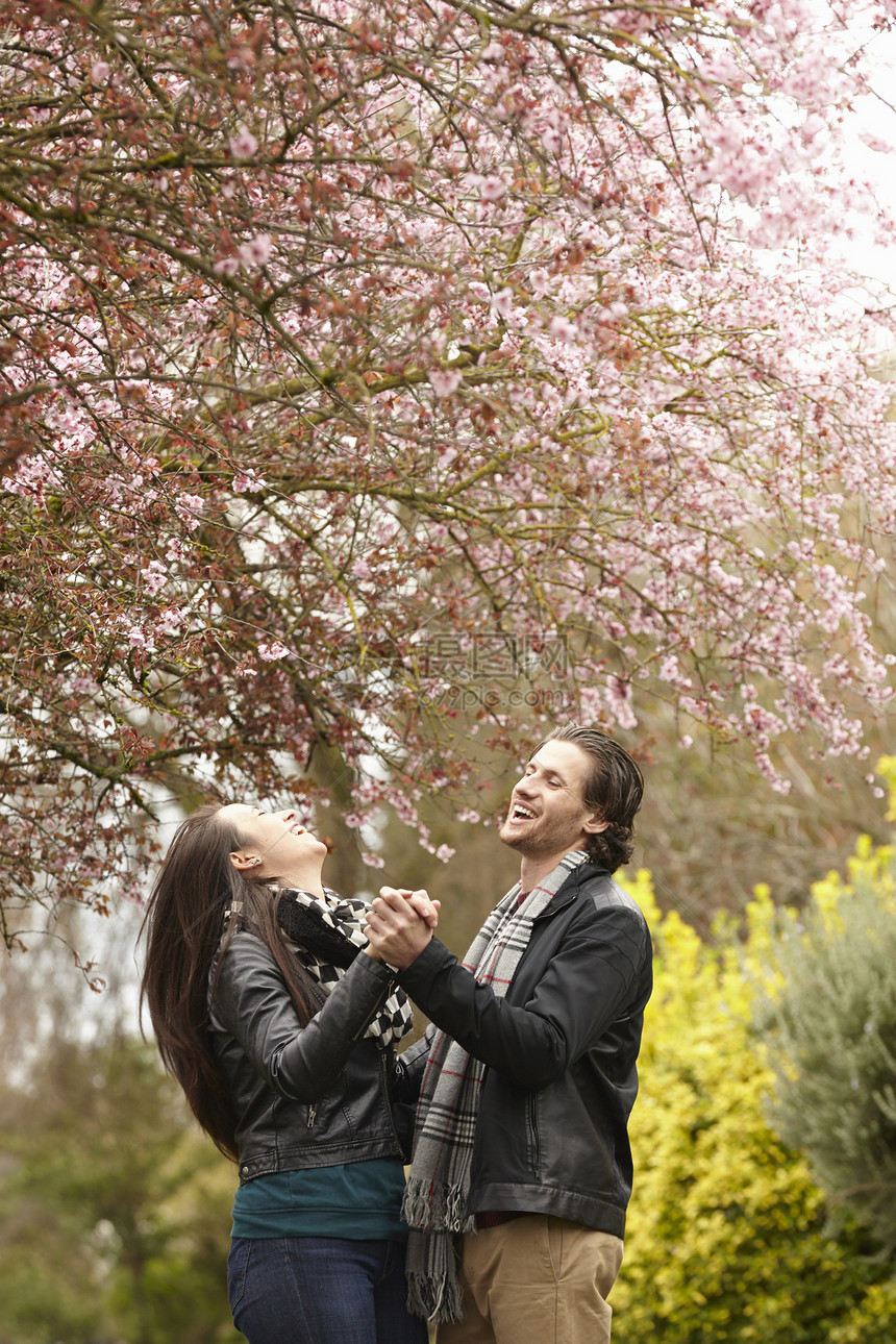 年轻夫妇在公园花下跳舞图片