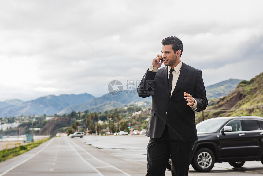 沿海高速公路上的年轻商人用手机打电话图片