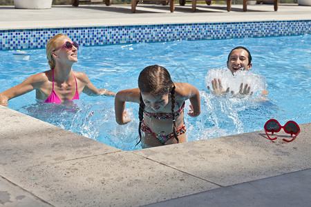 年轻家庭在户外游泳池里玩耍图片