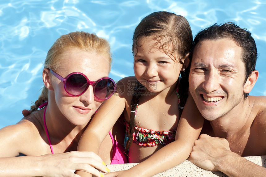 户外游泳池中年轻家庭的肖像图片