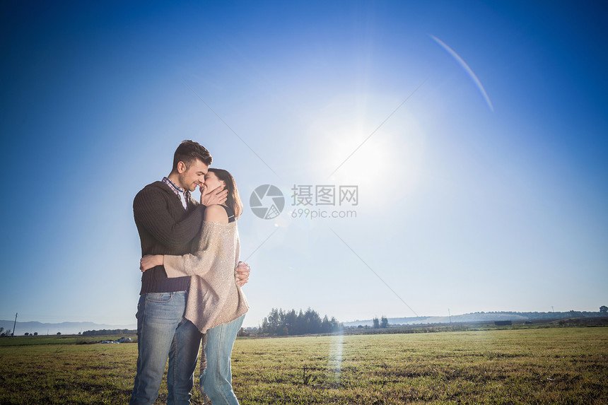 在野外接吻的年轻夫妇图片