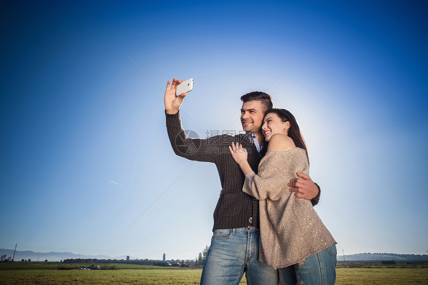 年轻夫妇在蓝天自拍图片