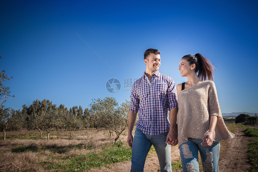 在野外手牵手的年轻夫妇图片