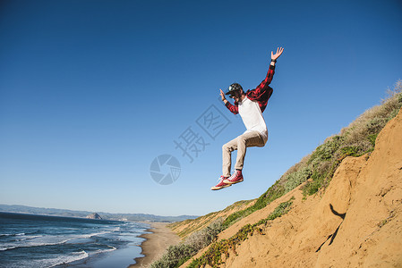 年轻人跳下沙山空中图片