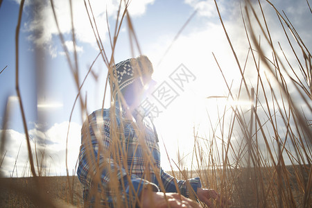 阳光下芦苇地里的成熟男子图片