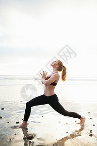 在沙滩上做瑜伽姿势的成年女子图片