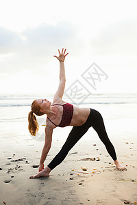 在沙滩上做瑜伽姿势的成年女子图片