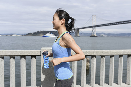 在海湾大桥拿着水壶跑步的女人图片