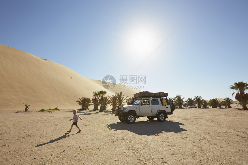 非洲纳米布纳克卢夫特公园沙丘上行走的男孩图片