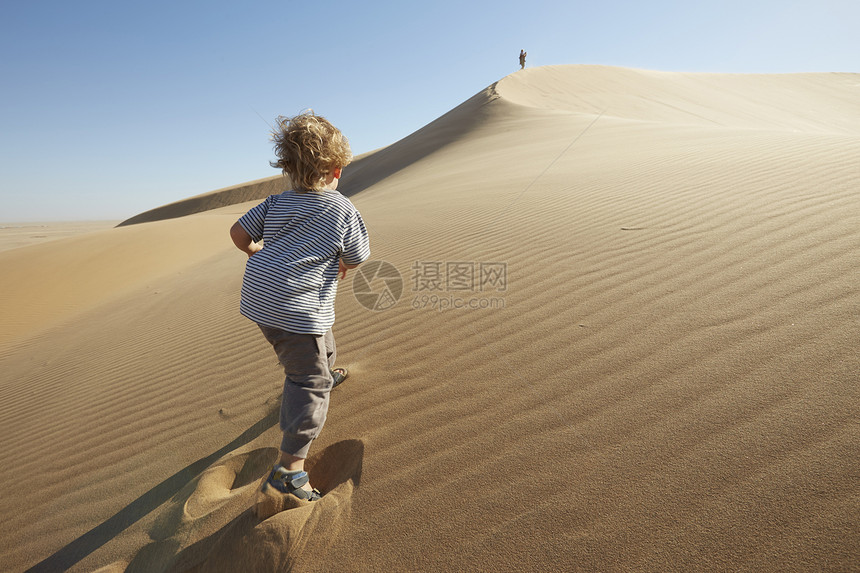 男孩在沙丘上奔跑图片