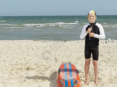 海滩上小男孩加固帽子图片