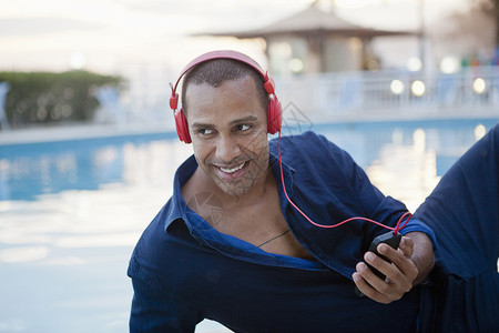 游泳池带着耳机听音乐的中年男性图片