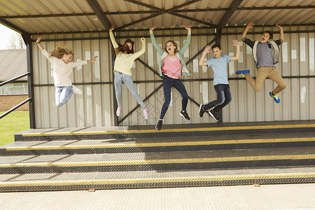5名青少年在体育场跳起来欢呼图片