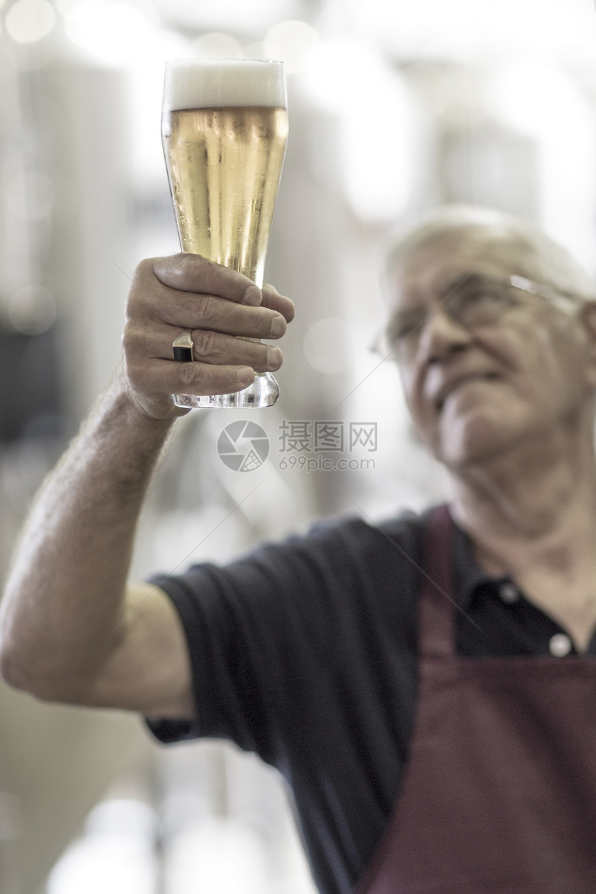 中年男子手举啤酒杯图片