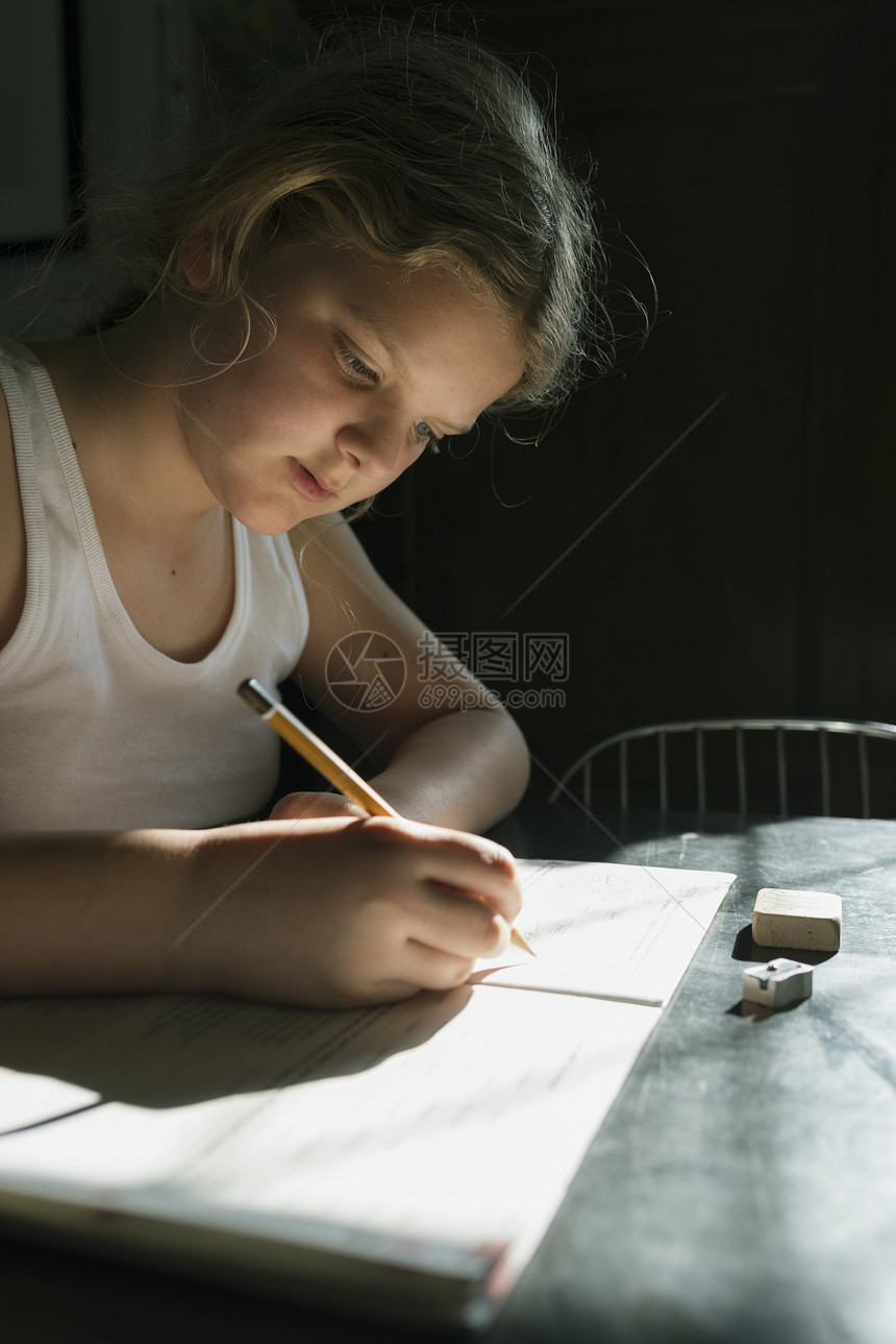 女孩使用笔和本子做功课图片