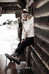 冬季女性坐在小木屋外图片