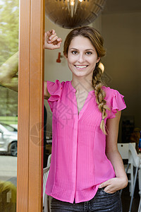 坐在咖啡厅门口的年轻女子背景图片