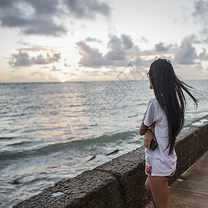 在海边看日出的年轻女子高清图片