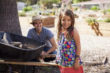 与父亲一起在社区花园里的女孩肖像图片
