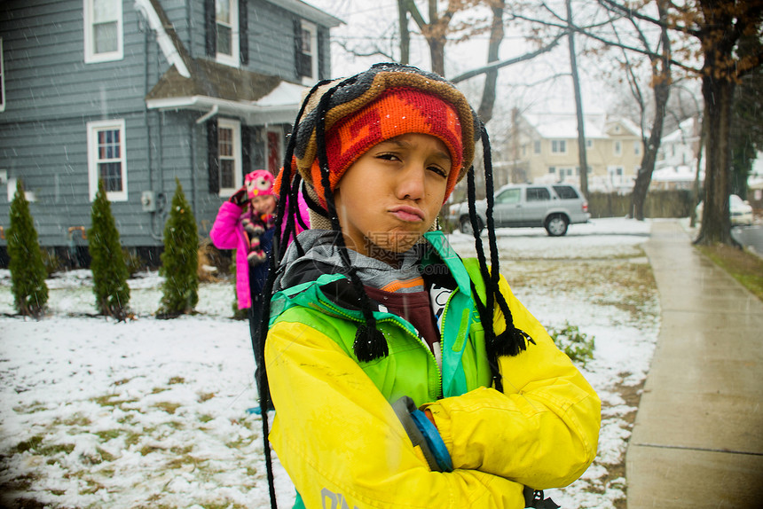 在雪地花园里两名戴着毛衣帽的青少年做鬼脸图片