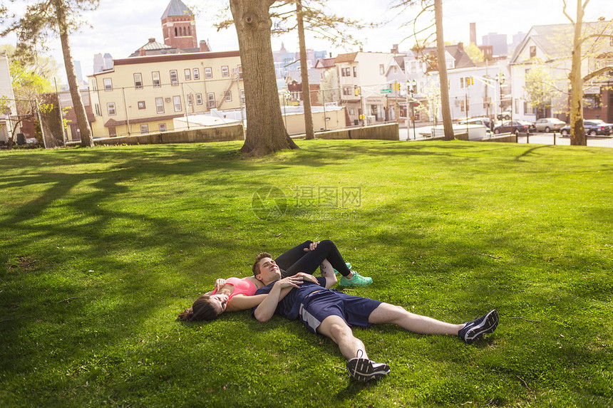 躺在公园草地上休息的年轻夫妇图片