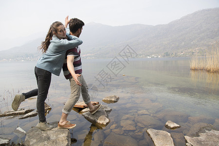 一对夫妇在岩石上踩着过桥图片