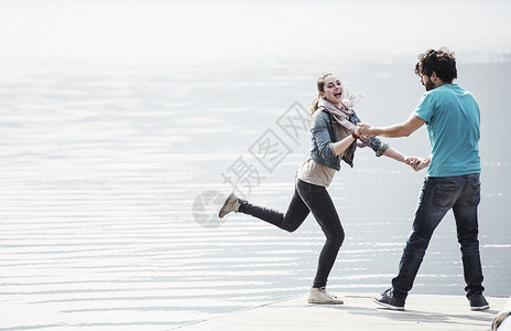 年轻夫妇在湖边码头玩耍图片