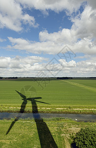 草地上风力涡轮机的影子图片